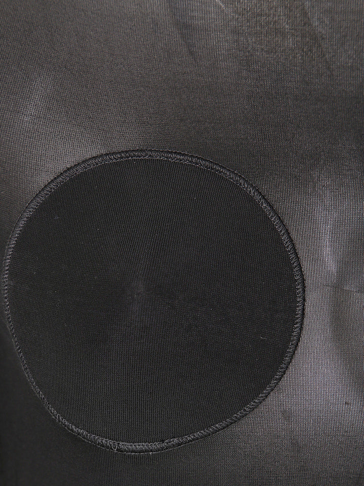 Black circular patch on a textured gray surface
