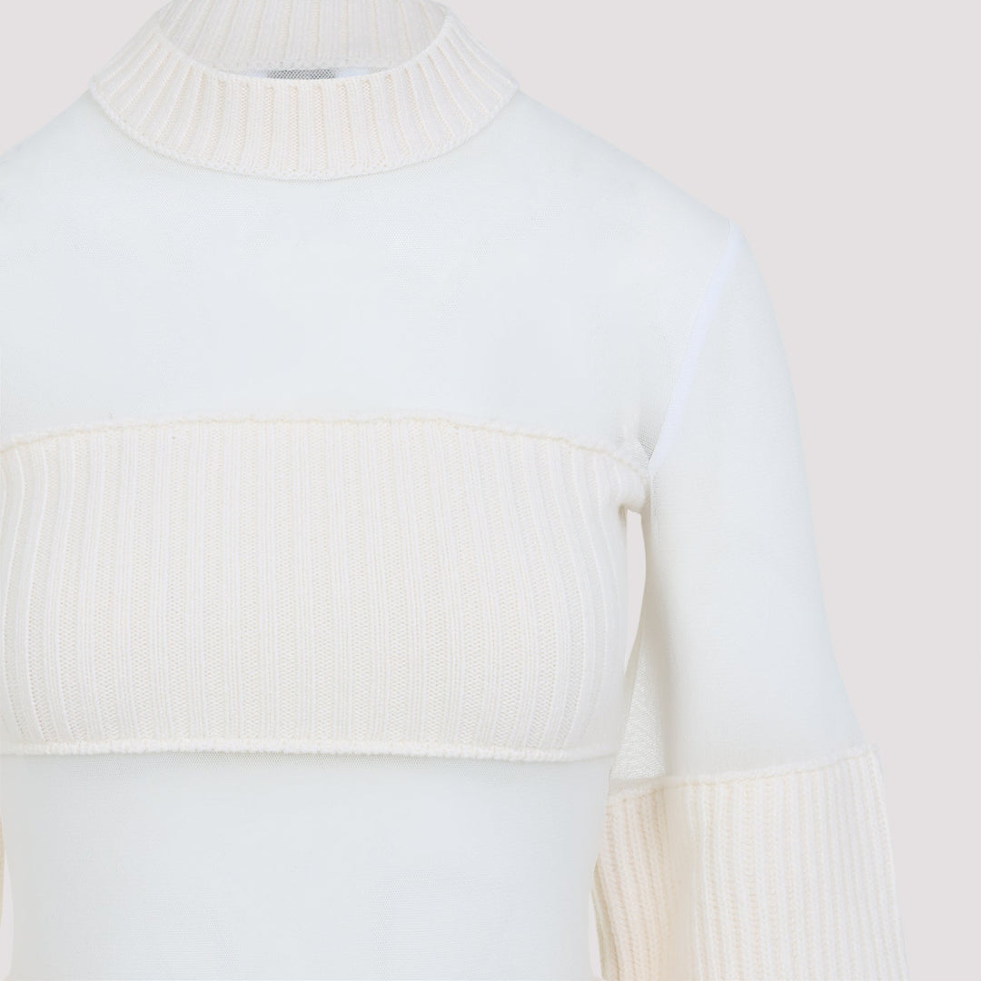 Close-up of a white sweater with ribbed texture on a light background