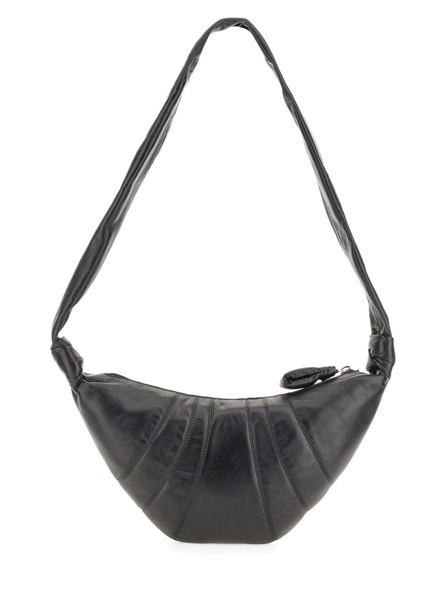 Black handbag with a strap on a white background