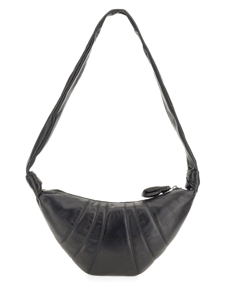 Black handbag with a strap on a white background