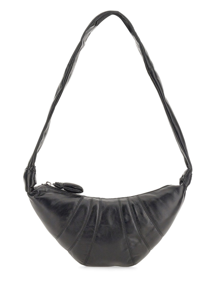 Black leather handbag with a shoulder strap on a white background