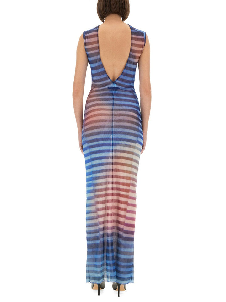 Woman wearing a multicolored striped dress with an open back on a white background