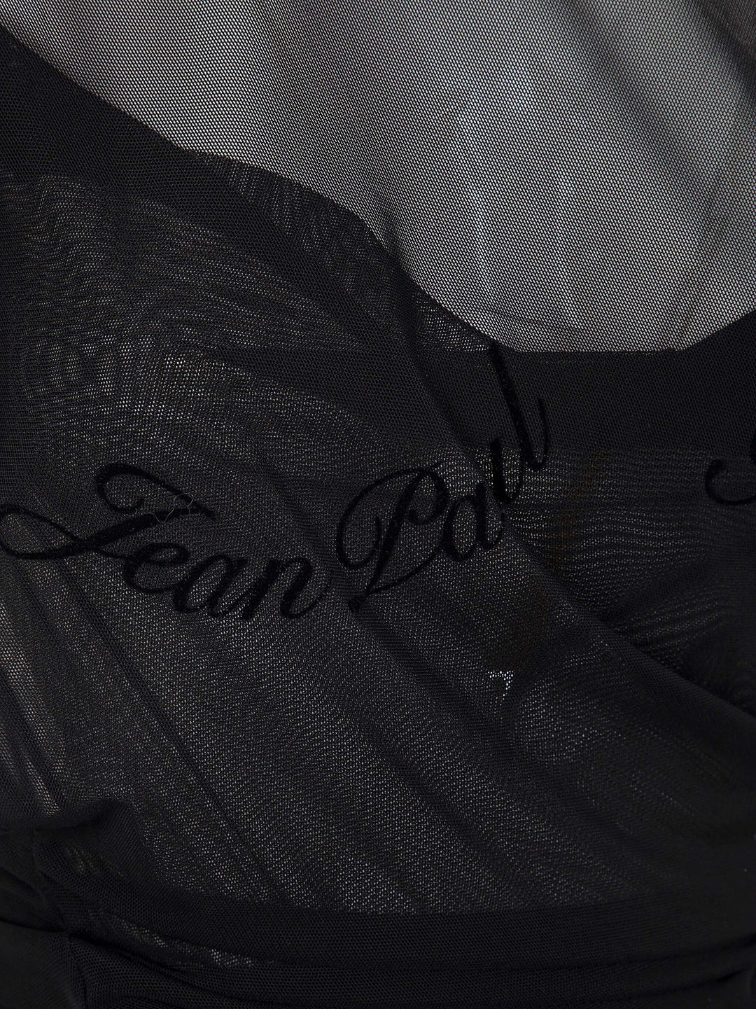 Close-up of a black garment with 'Jean Paul' branding.