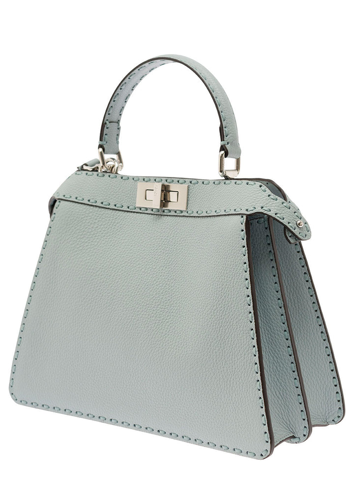 Light blue handbag with a gold clasp on a white background