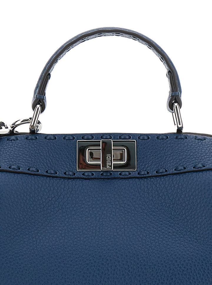 Blue handbag with a silver handle and clasp on a white background