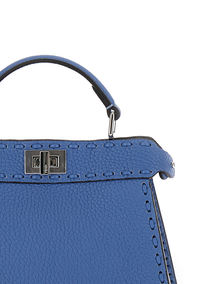 Close-up of a blue handbag with a silver clasp on a white background