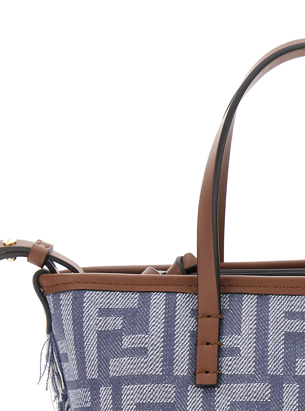 Close-up of a blue patterned handbag with brown leather handle and trim on a white background