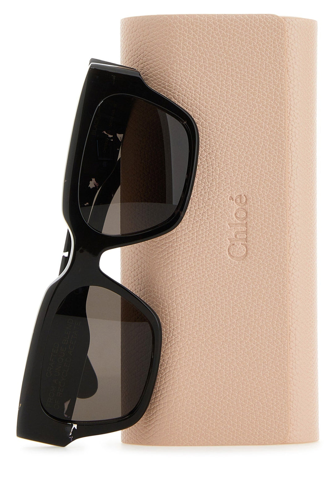 Black sunglasses on a beige fabric with 'Chloe' branding