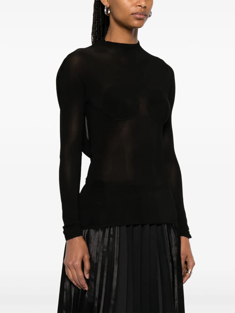 Person wearing a black long-sleeve top on a white background