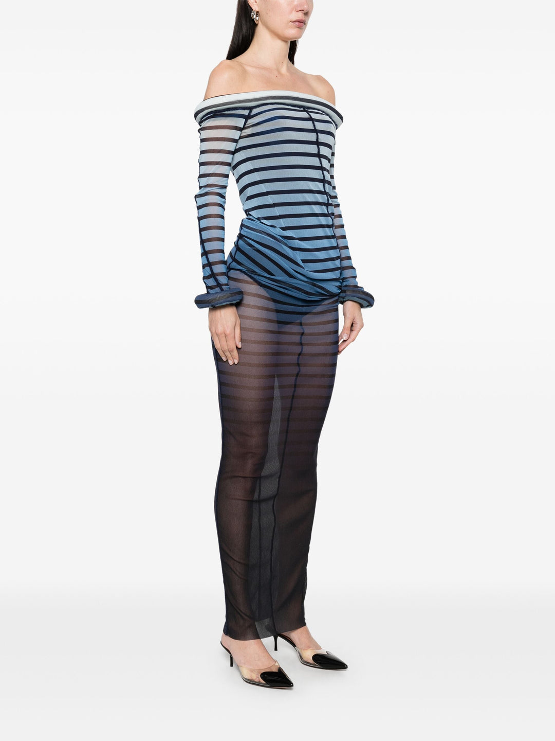 Woman wearing a blue and black striped dress with sheer overlay on a white background