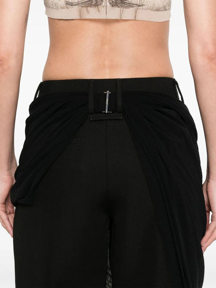 Black drape pants worn by a person on a plain background