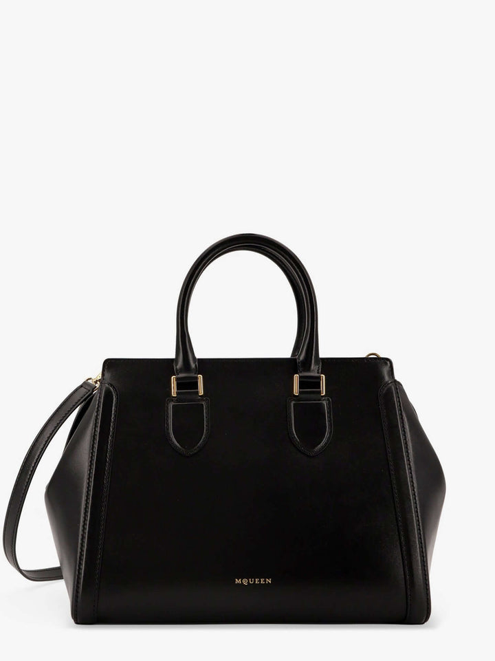 Black handbag with gold hardware on a white background