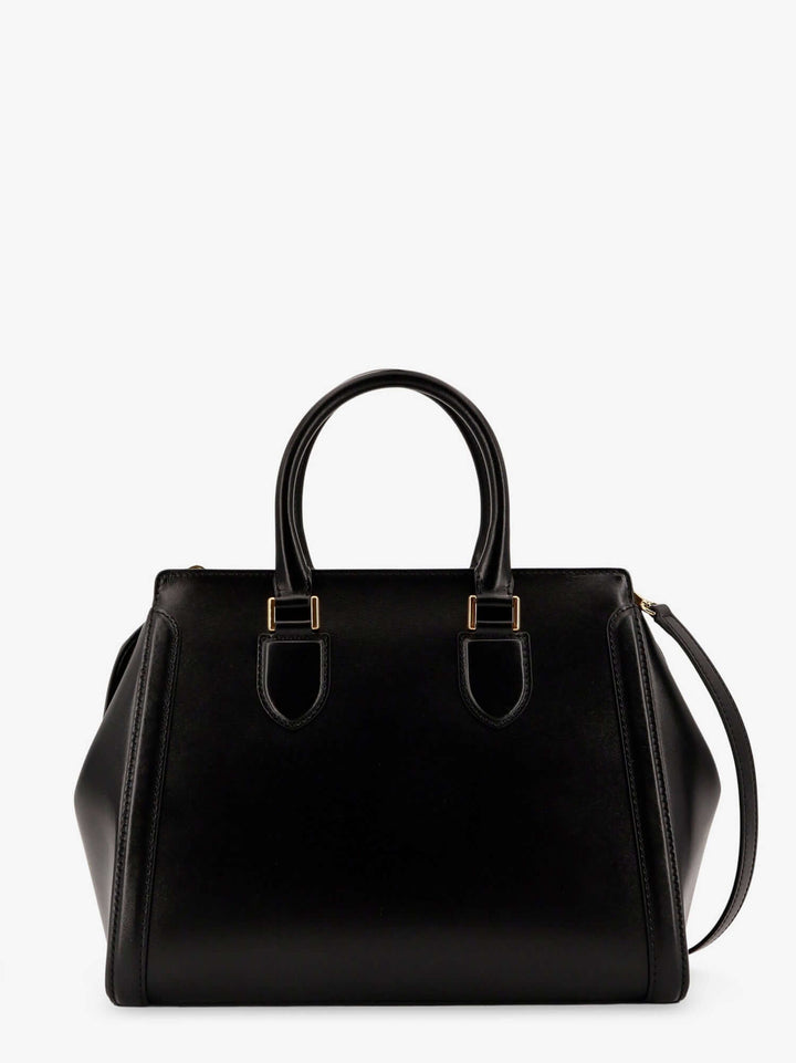 Black handbag with gold hardware on a white background