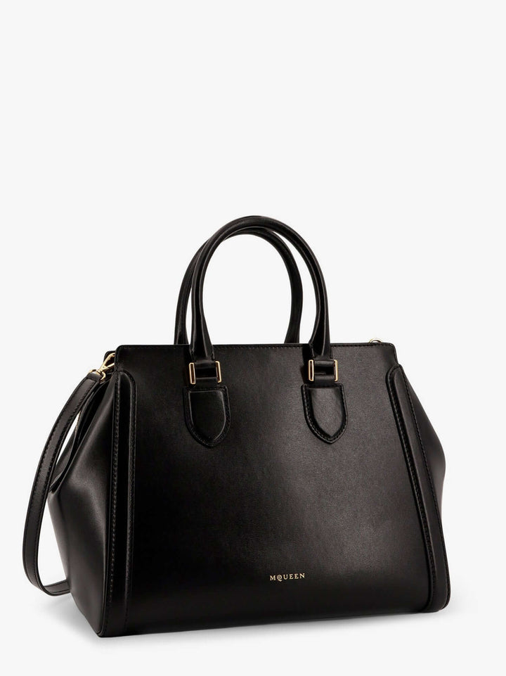Black handbag with gold hardware on a white background