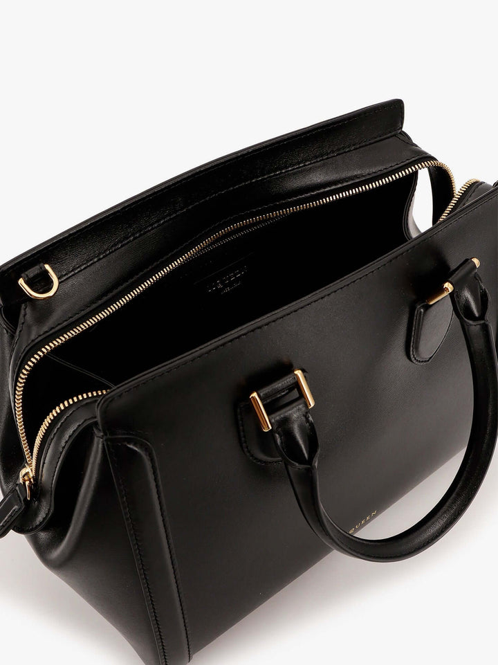 Black handbag with gold accents on a white background