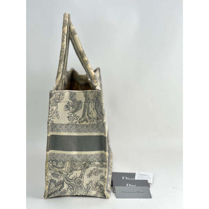 Designer handbag with floral pattern and 'Dior' tag on a white background