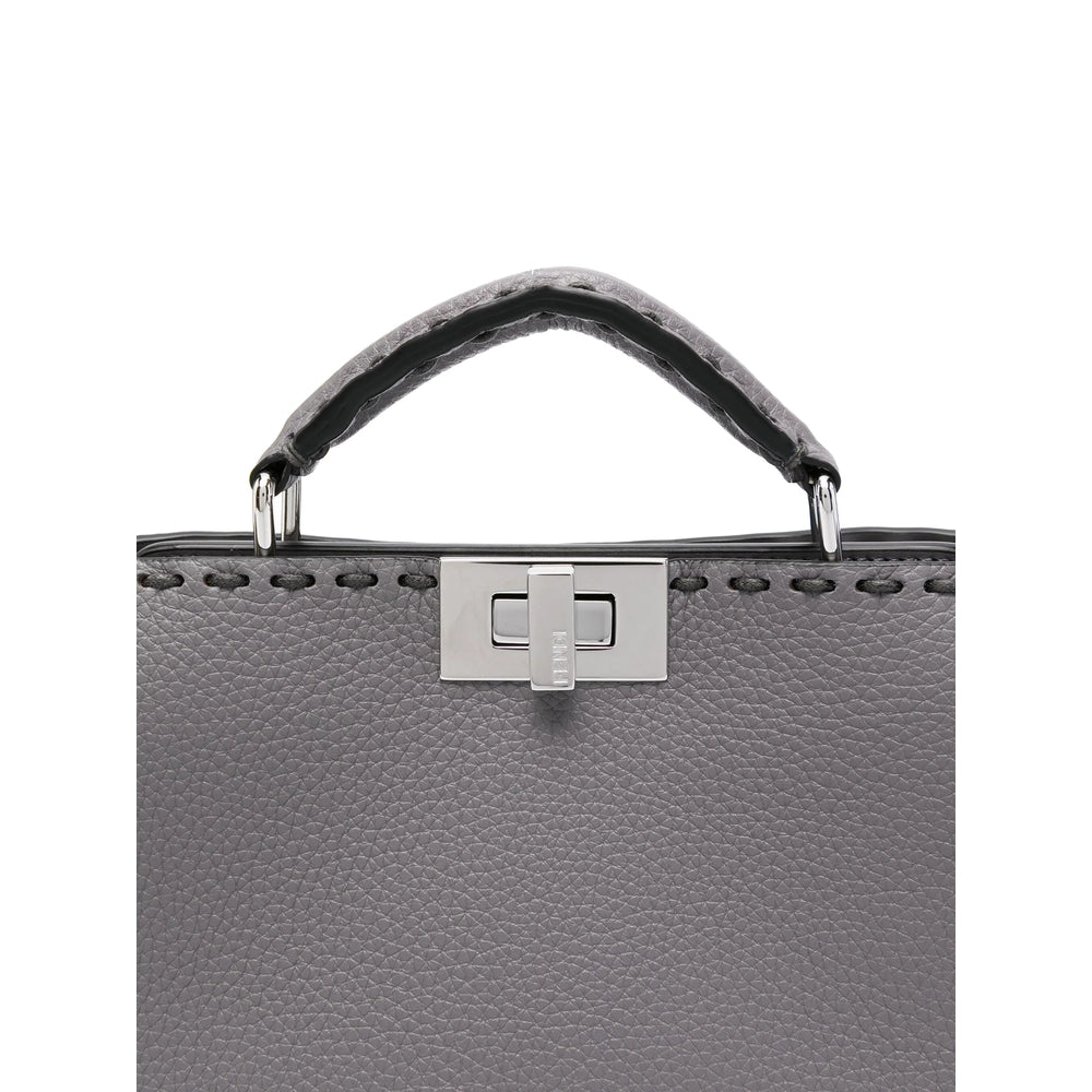 Gray leather handbag with a silver clasp on a white background