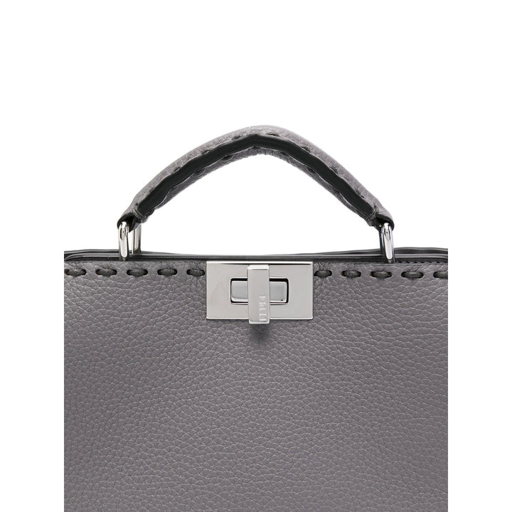 Gray leather handbag with a silver clasp on a white background