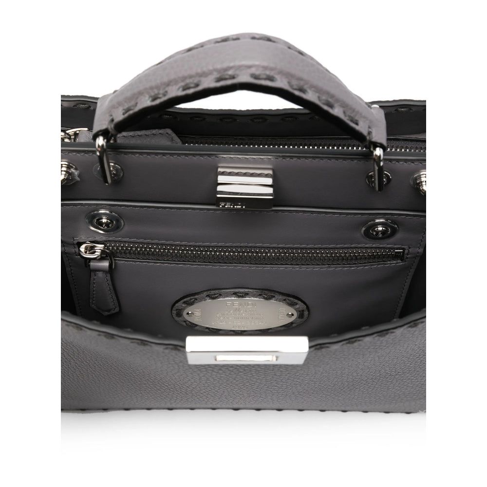 Close-up of a black handbag with a silver clasp on a white background