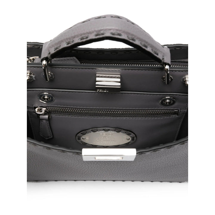 Close-up of a black handbag with a silver clasp on a white background