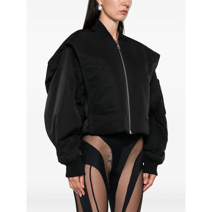 Person wearing a black bomber jacket on a white background
