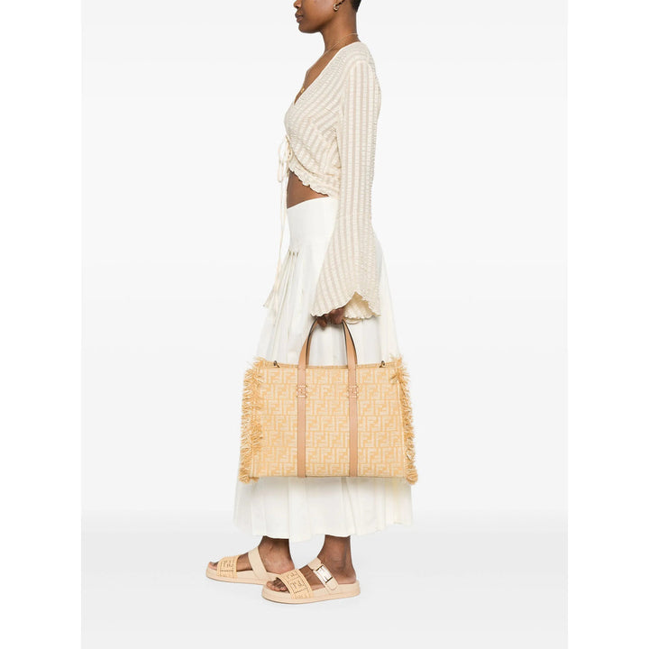 Woman holding a straw bag against a white background