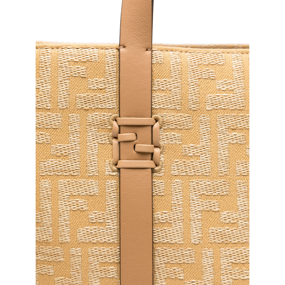 Close-up of a beige handbag with a woven pattern and brown strap on a white background