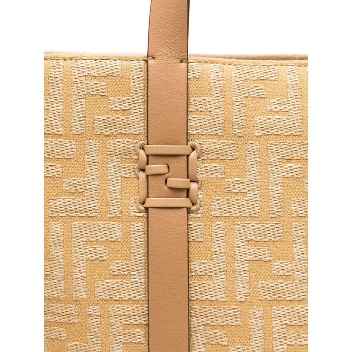 Close-up of a beige handbag with a woven pattern and brown strap on a white background
