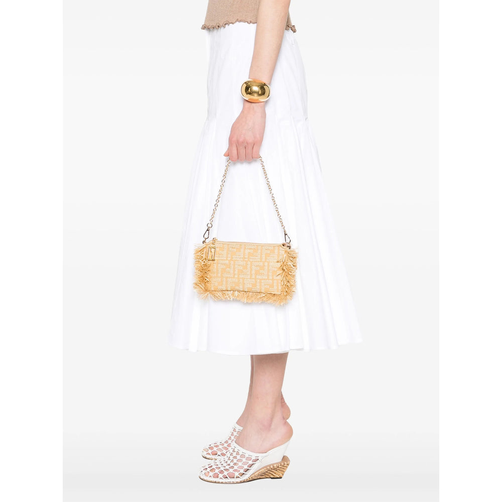 Person holding a straw handbag with a plain white background