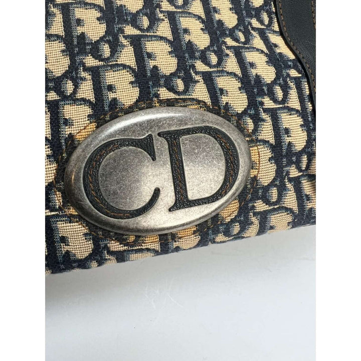 Close-up of the CD emblem on the CHRISTIAN DIOR Monogram Trotter CD Blue Canvas Hand Bag, showcasing luxury bags design details.