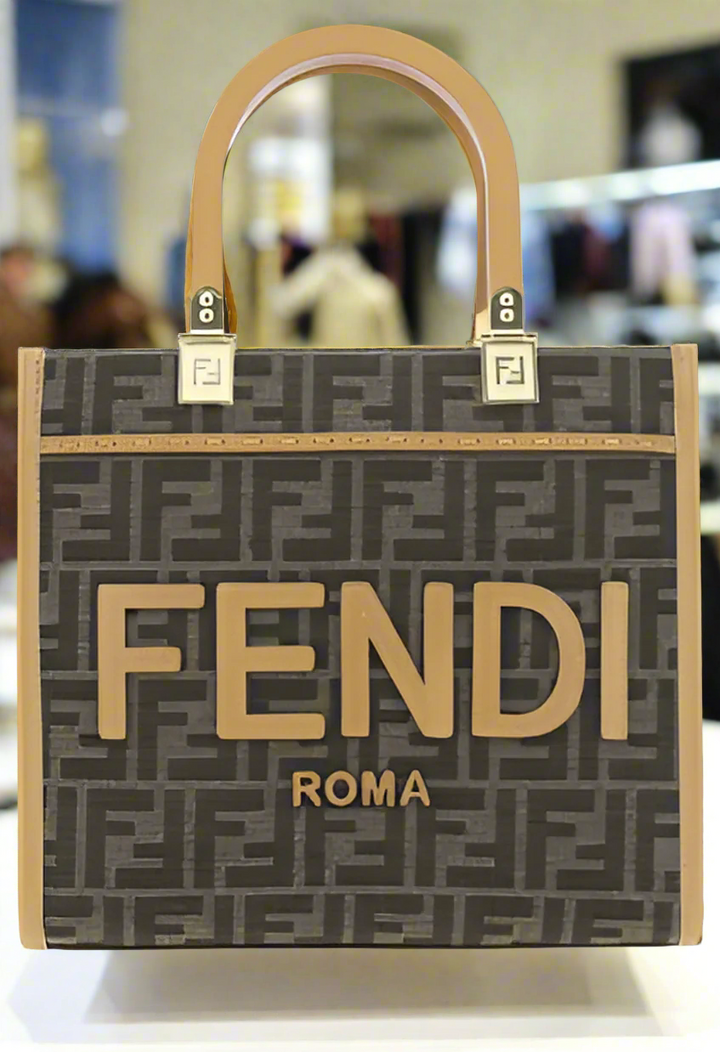 A brown Fendi Roma women's shopping bag with the brand's logo embossed on the side, featuring two rigid handles and a flat leather shoulder strap.