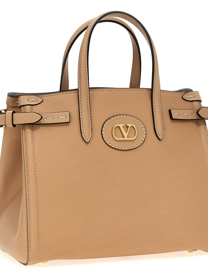 Tan handbag with a visible brand logo on a white background