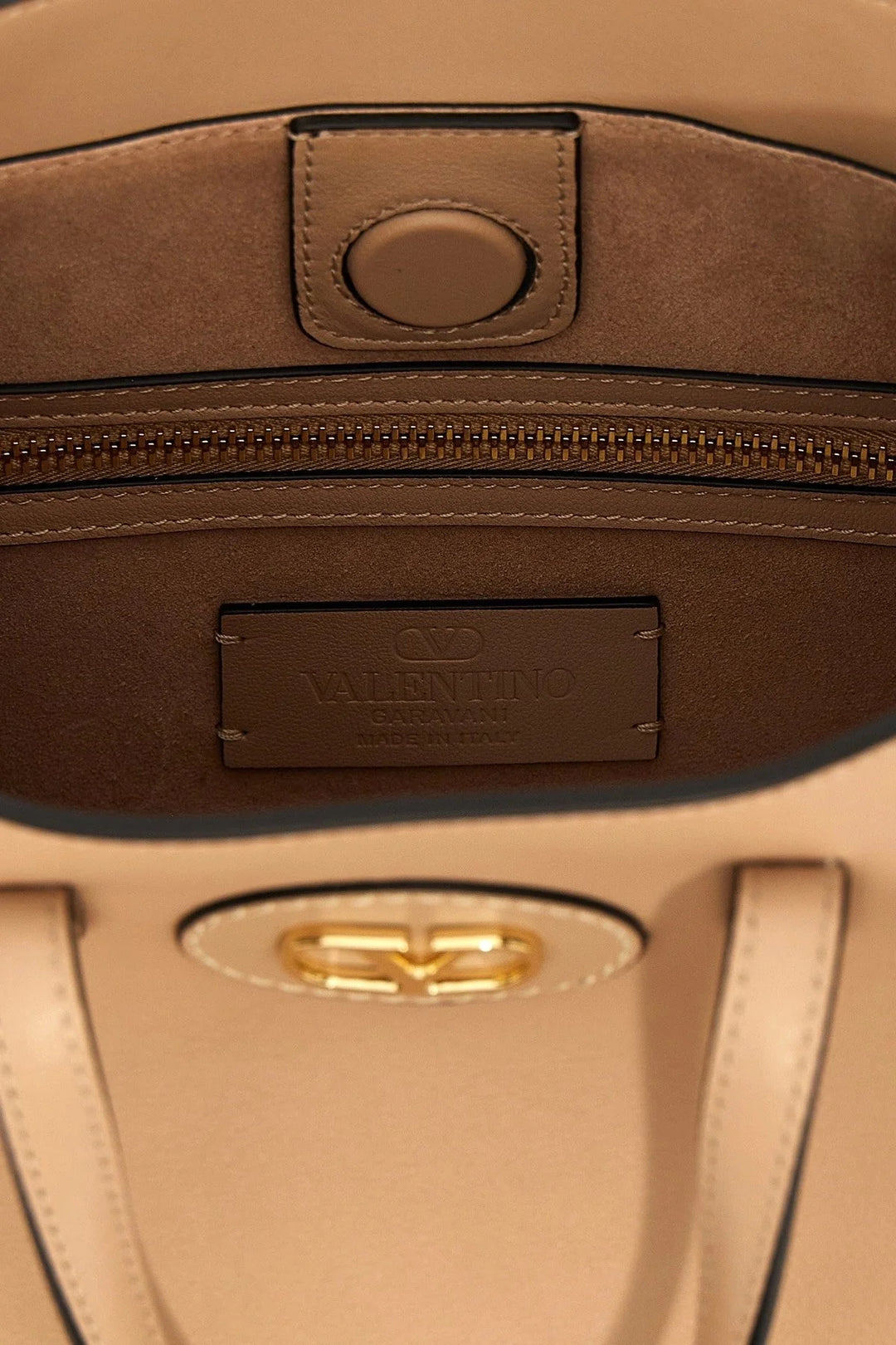 Close-up of a brown leather bag with a visible brand logo.