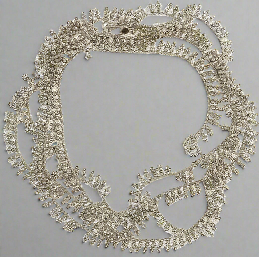 Silver necklace with intricate design on a white background