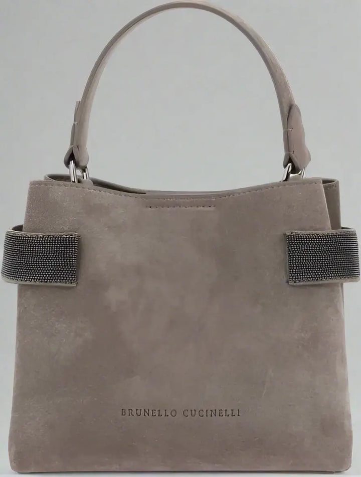 Gray handbag with black straps and 'Brunello Cucinelli' branding on a white background