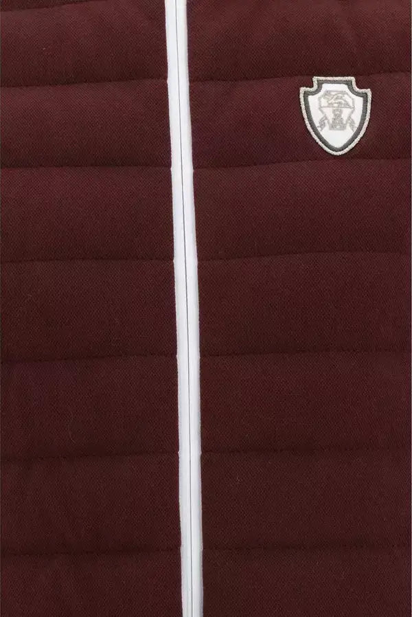 Maroon puffer jacket with a white zipper and logo on a dark background