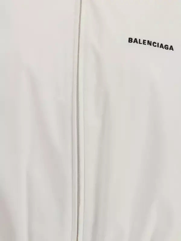 Close-up of a white jacket with 'BALENCIAGA' logo on a light gray background