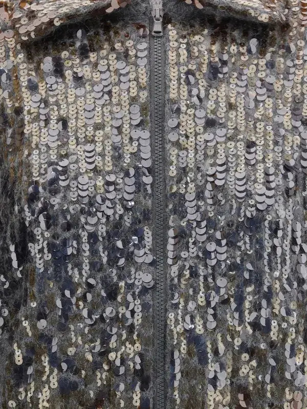 Close-up of a sequined fabric with a zipper running through it.