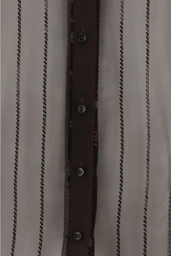 Close-up of a shirt with a brown belt and button details on a beige background