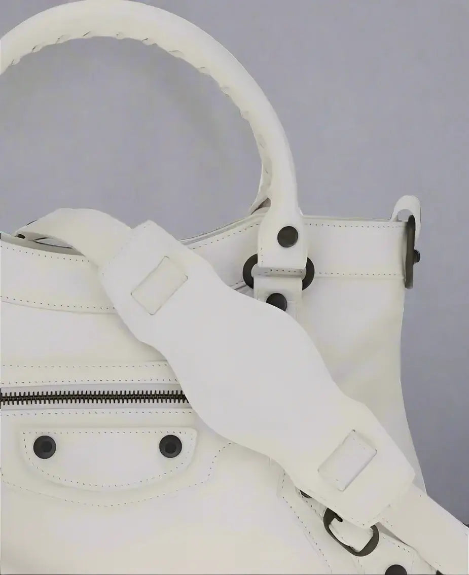 White leather handbag with a strap on a white background
