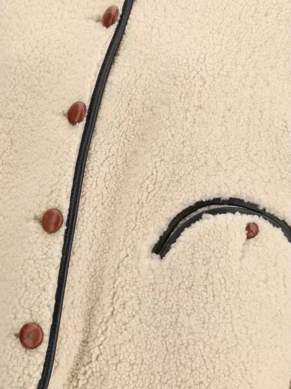 Close-up of a textured fabric surface with buttons and a black cord.