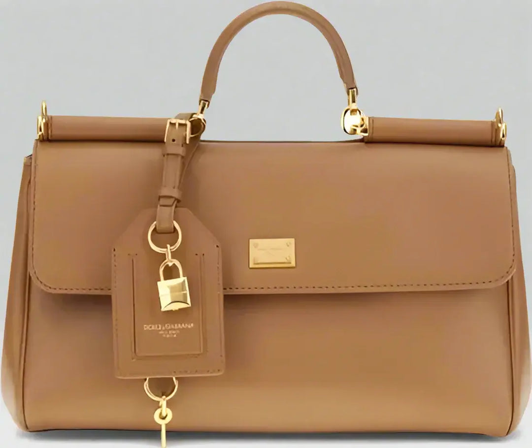 Brown leather handbag with gold accents on a white background