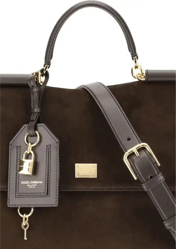 Brown leather handbag with gold accents and a visible brand tag on a white background