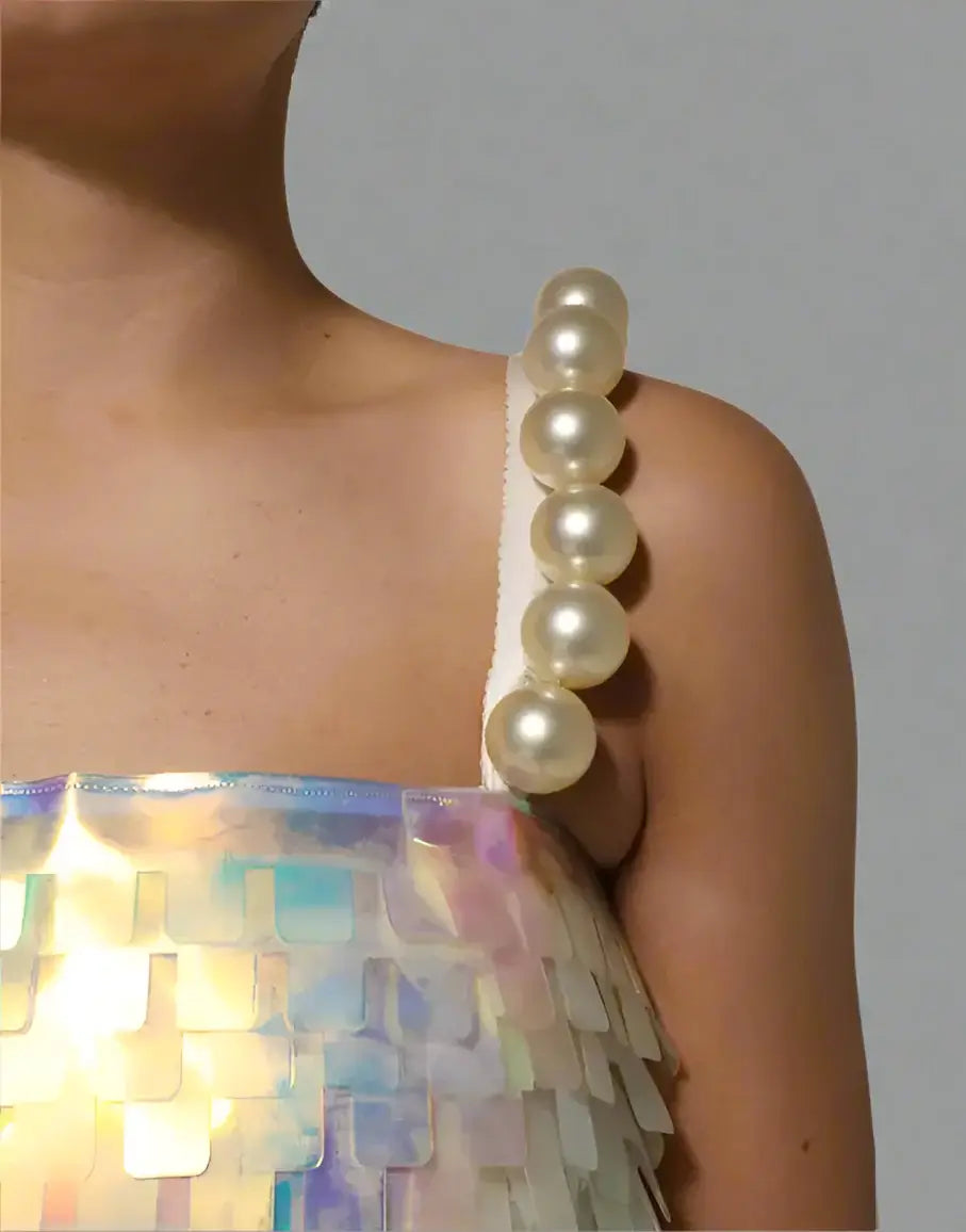 Pearl necklace on a person wearing a colorful dress with a white background