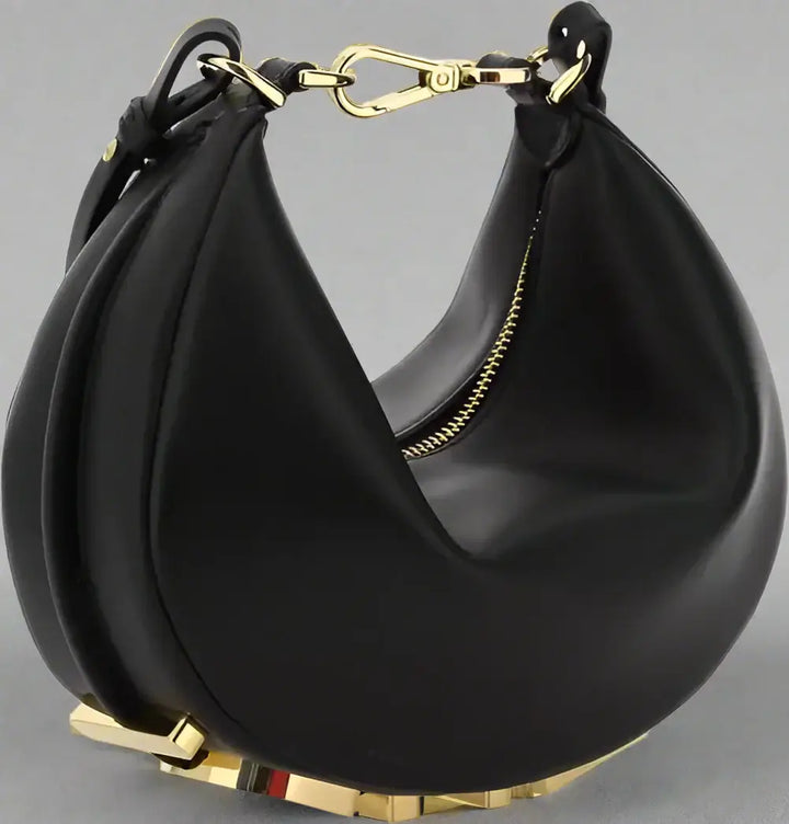 Black handbag with gold accents on a white background