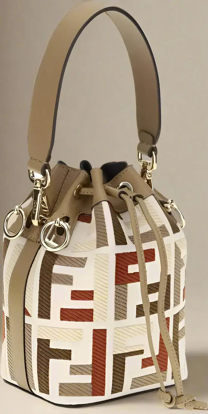Designer handbag with geometric pattern and tan handle on a white background