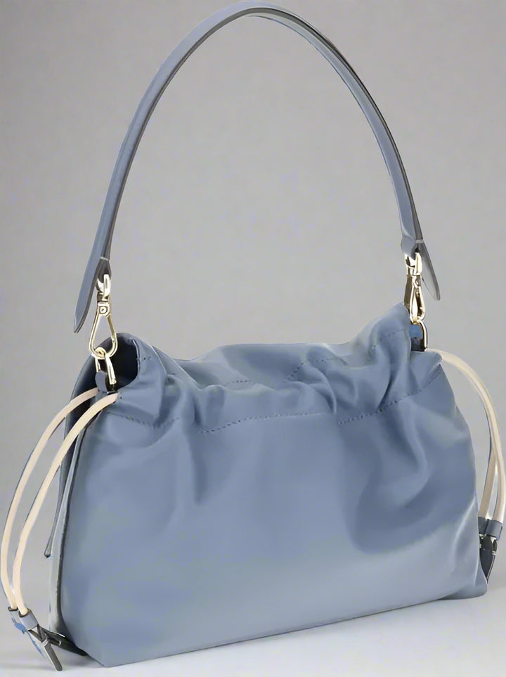 Blue handbag with a shoulder strap on a white background