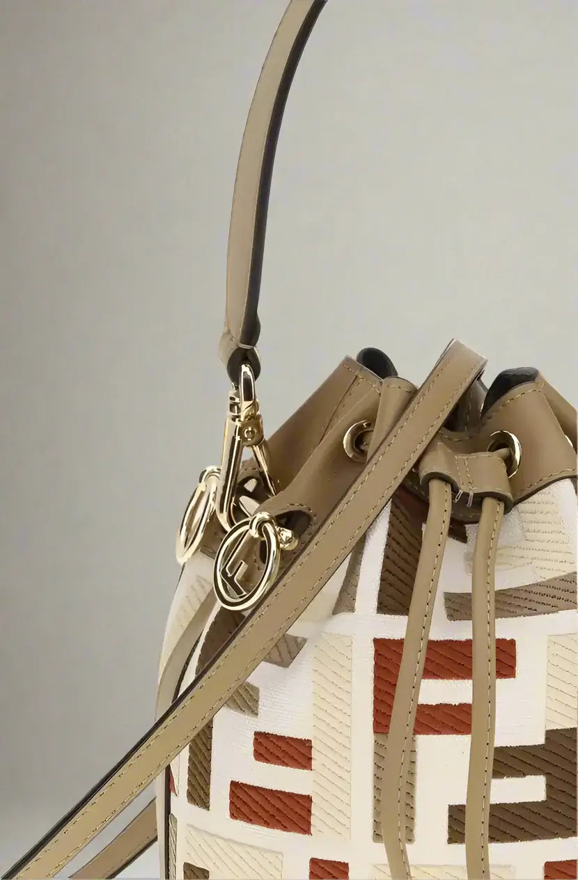 Close-up of a patterned handbag with a beige strap on a white background