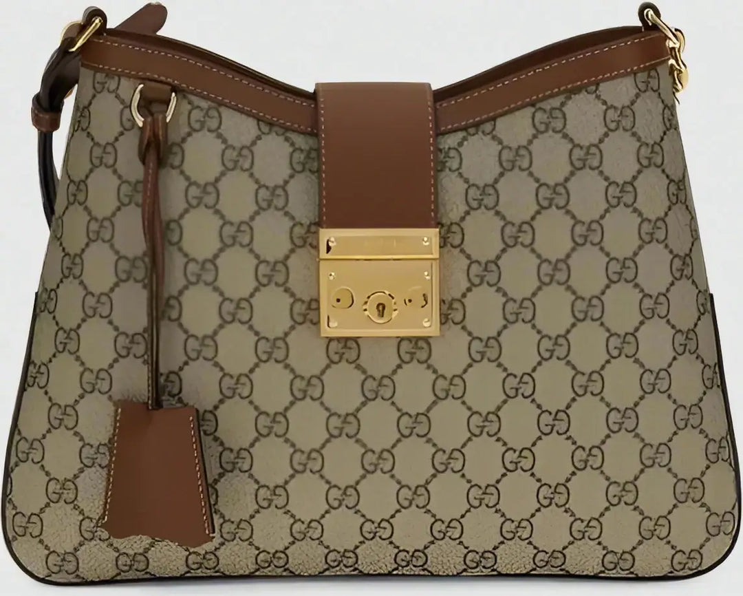 Designer handbag with brown and beige patterned fabric and gold lock detail.