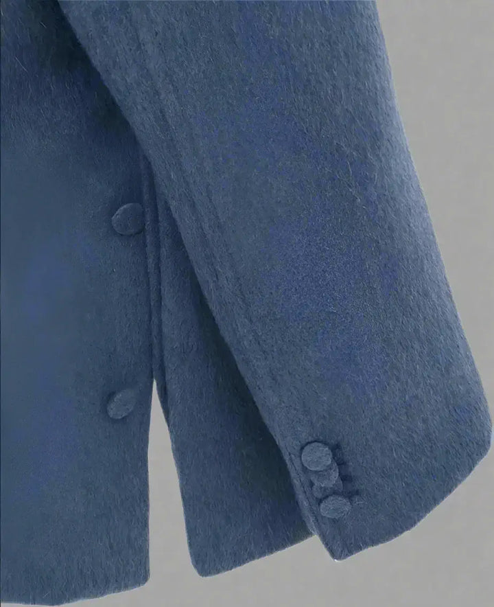 Close-up of a blue coat with buttons on a white background